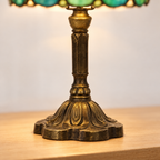 Gros plan du pied ouvragé de la lampe de chevet Tiffany Perlée Émeraude