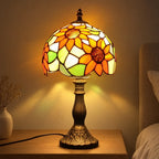 Lampe de chevet Tiffany Tournesol allumée la nuit, halo chaud sur le mur